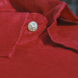 Close-up of a red hemp fabric showing the softness of the fibres with a button on a blurred background