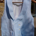 blue hemp waistcoat worn for weddings or royal ascot hangs from wooden hanger