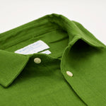 Close-up of a green shirt showing the detail and softness of the hemp fabric with collar and buttons on a white background