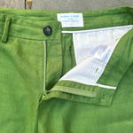 Close-up of sustainable, green hemp shorts with a brand label on a concrete surface