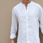 White button-up hemp shirt worn by a person against a beige wall