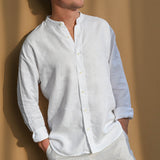 Man wearing a white collarless hemp shirt against a beige background