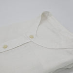 Close-up of a white hemp shirt with mandarin style collar and buttons on a white background