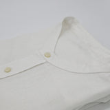 Close-up of a white hemp shirt with mandarin style collar and buttons on a white background