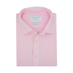 Product shot of neatly folded pink hemp shirt with a label on a white background