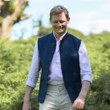 Man wearing a navy blue nehru gilet made from hemp fabric over a light pink shirt with a blurred natural background