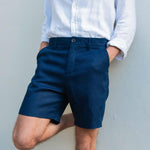 Person wearing navy blue hemp shorts and a white shirt against a plain background