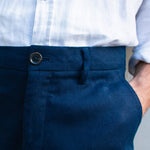 Navy blue hemp shorts with a white shirt worn by a person with his hand in his pocket
