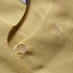 close up of yellow hemp fabric with detailed shot of buttons
