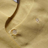 close up of yellow hemp fabric with detailed shot of buttons