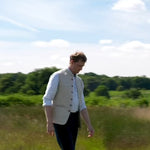 slow motion video showing man walking in a field to show the customer how the hemp fabric behaves and moves