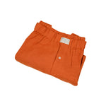 Neatly folded orange hemp boxer shorts with a label on a white background