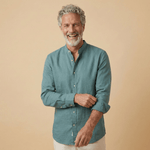 Man wearing a teal coloured hemp fabric shirt with grandad collar against a beige background