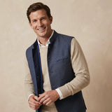 Man wearing a blue nehru gilet made from hemp fabric over a beige sweater against a beige background