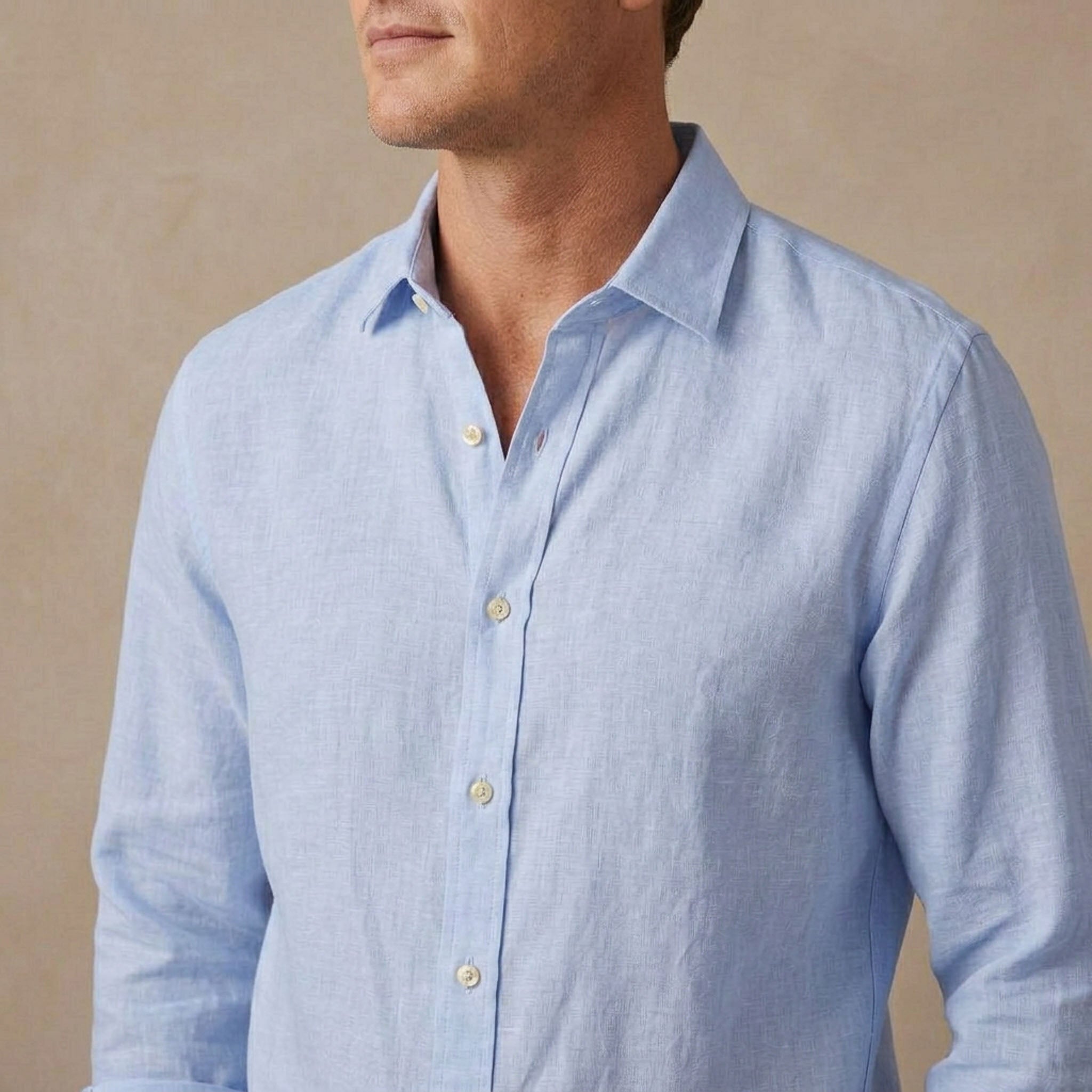 A man wearing a light blue long-sleeve hemp shirt, cropped from the lower face to the chest, against a neutral beige background.
