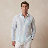 Man wearing a striped light blue and white striped shirt made from hemp fabric against a beige background