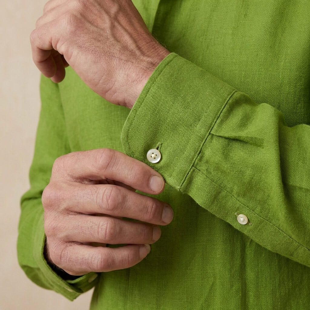 closeup shot of the cuff and button being fastened on a heavy weight hemp shirt colour green