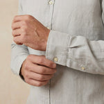 closeup shot of the cuff and button being fastened on a hemp shirt colour light grey