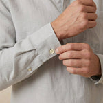 closeup shot of the cuff and button being fastened on a hemp shirt with pocket colour grey
