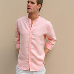 Man wearing a light peach collarless hemp shirt against a beige background