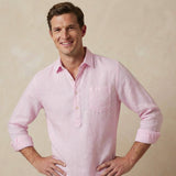 Man wearing a light pink shirt made from sustainable hemp fabric against a beige background