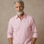 Man wearing a pink hemp shirt which is better than linen against a beige background