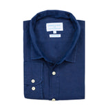 Neatly folded blue hemp shirt with a visible brand label on a white background