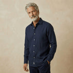 Man wearing a navy blue hemp shirt against a beige background