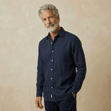 Man wearing a navy blue hemp shirt against a beige background