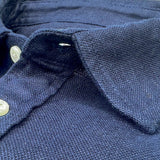 Close-up of a navy blue hemp shirt collar with buttons.