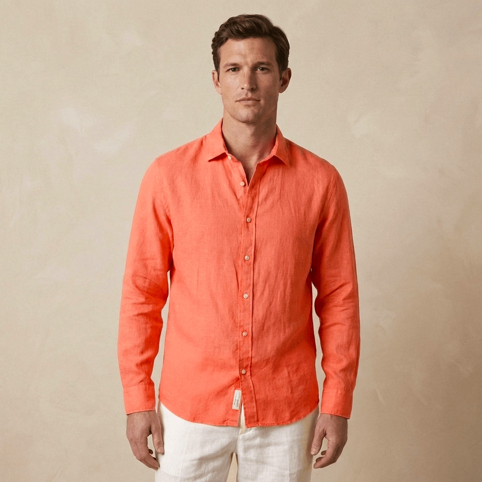 Man wearing an coral or orange shirt against a beige background