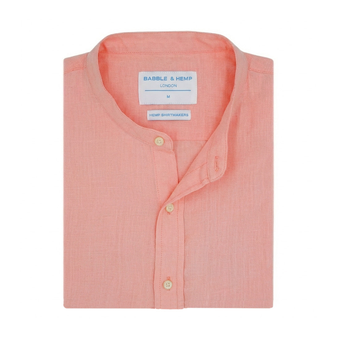 Folded pink hemp shirt with grandad collar and with a label on a white background