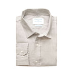 Folded light grey dress shirt with a label on a white background