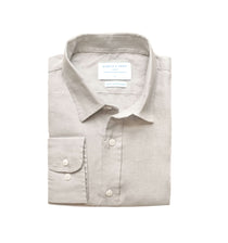 Folded light grey dress shirt with a label on a white background