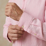 closeup shot of the cuff and button being fastened on a hemp shirt colour pink