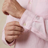 closeup shot of the cuff and button being fastened on a hemp shirt with pocket colour pink