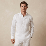 Man wearing a white long-sleeve shirt made from hemp fabric and trousers against a beige background