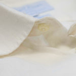 Close-up of the collar and top button on a white shirt showing the softness of the hemp fabric