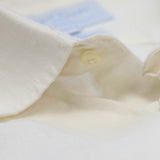 Close-up of the collar and top button on a white shirt showing the softness of the hemp fabric