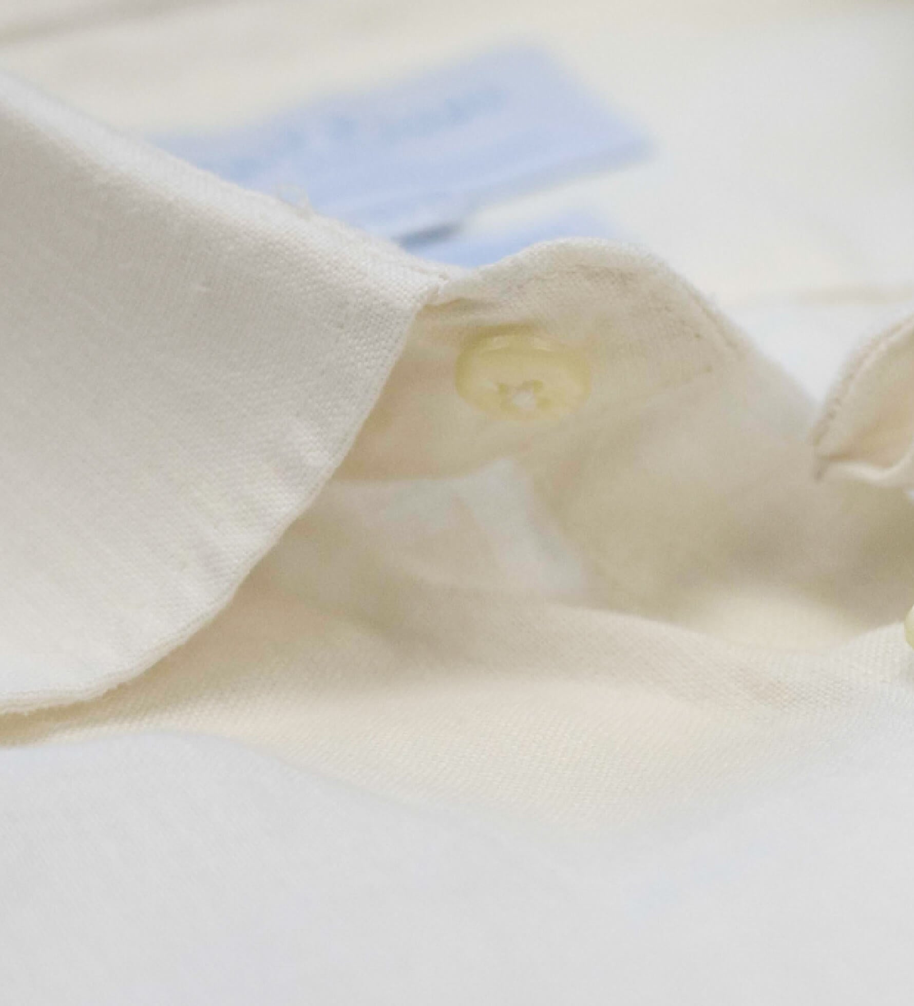 Close-up of the collar and top button on a white shirt showing the softness of the hemp fabric