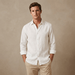 a man wears a crisp, white, hemp shirt with sleeves rolled up on a beige backdrop