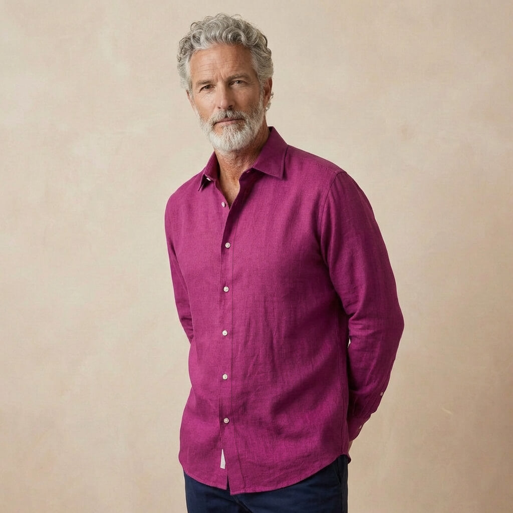 Man wearing a magenta or purple shirt against a beige background
