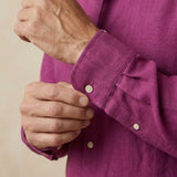 closeup shot of the cuff and button  being fastened on a hemp shirt colour purple