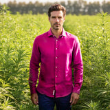 Man in a purple hemp shirt standing in a field of green plants