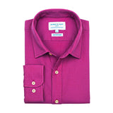 Product shot of folded purple hemp shirt with a label on a white background