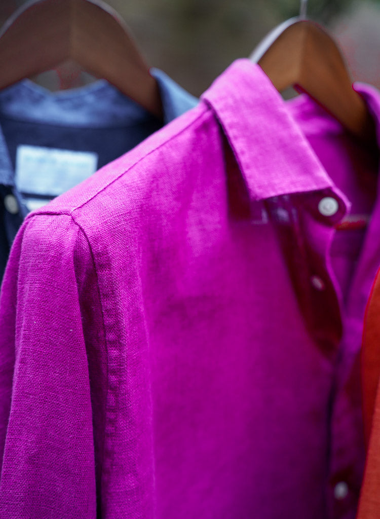 a closeup shot of a purple heavy hemp shirt on a hanger with close detail of the soft, fine fabric