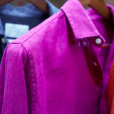 a closeup shot of a purple heavy hemp shirt on a hanger with close detail of the soft, fine fabric