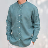 Teal long-sleeve, collarless hemp shirt worn by a person against a light background