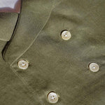 closeup of the green hemp fabric on the waistcoat and details of the buttons