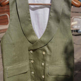 a formal green hemp waistcoat worn for weddings or royal ascot hangs from a wooden hanger
